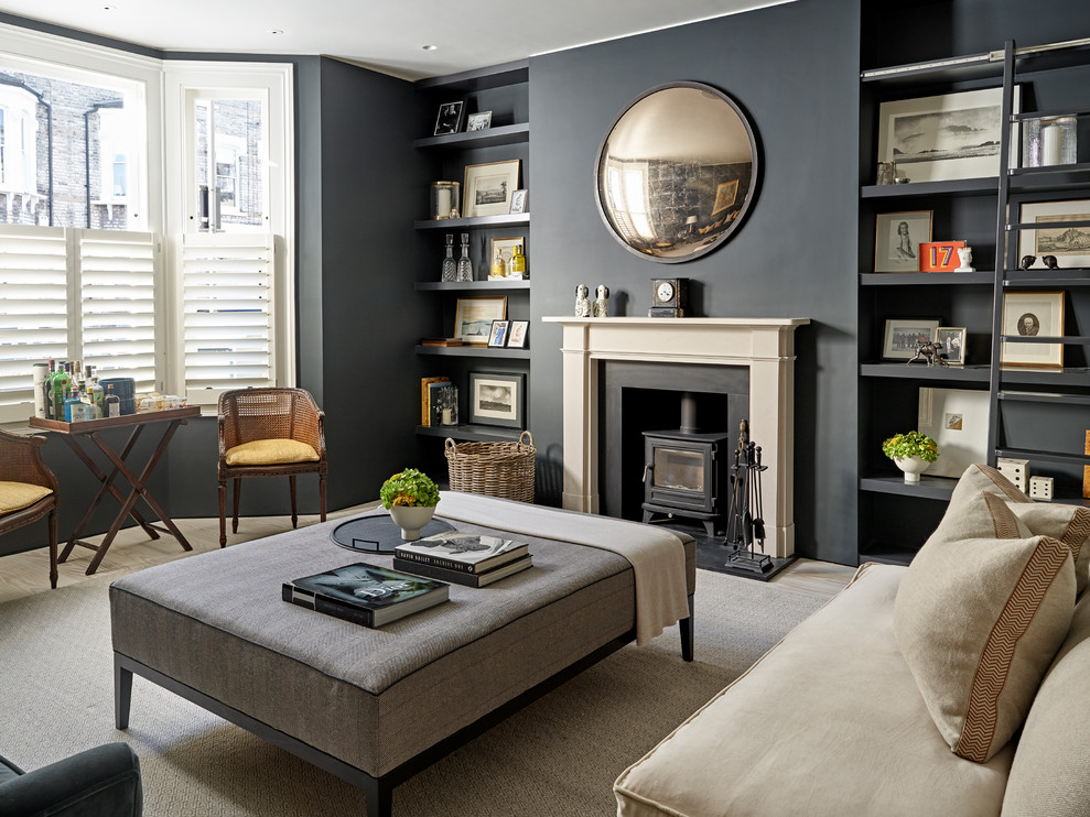 Photo of a transitional living room in London with grey walls, light hardwood floors, a wood stove and beige floor.
