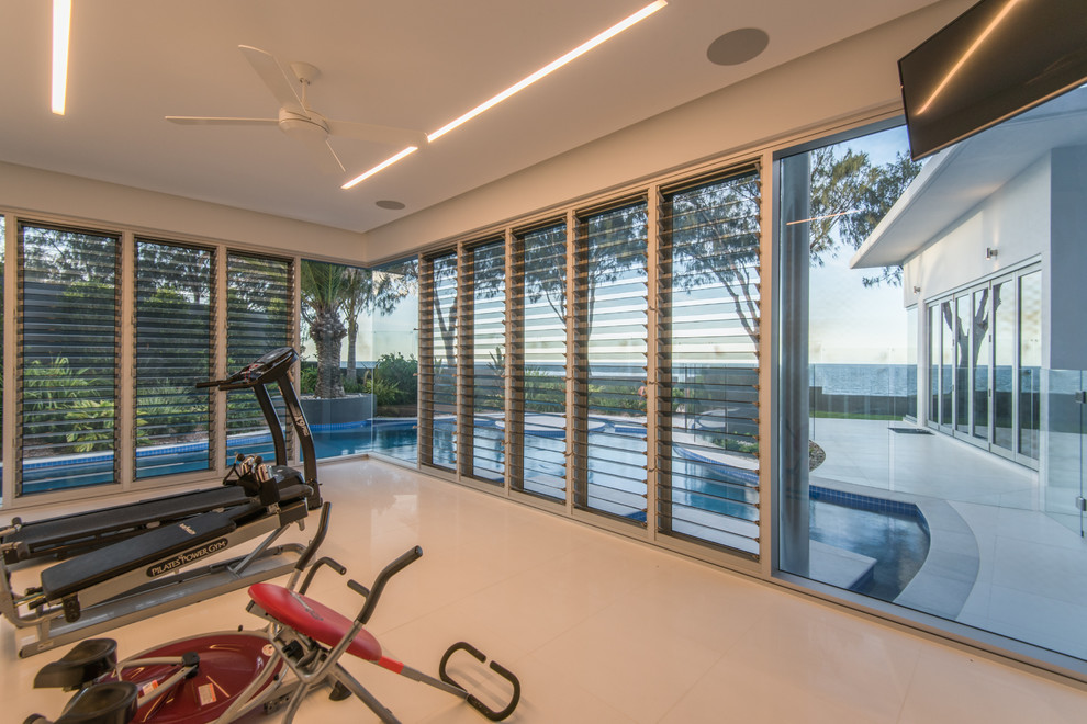 This is an example of a mid-sized modern multipurpose gym in Brisbane with white walls and porcelain floors.