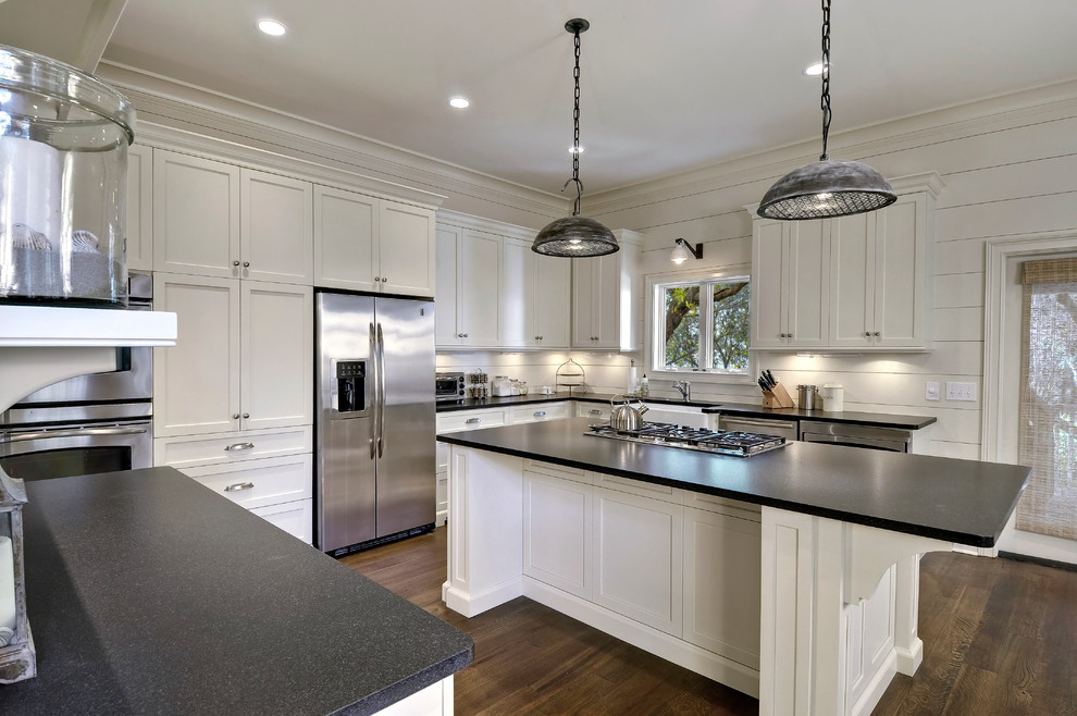 Photo of a mid-sized beach style u-shaped eat-in kitchen in Charleston with shaker cabinets, white cabinets, stainless steel appliances, a farmhouse sink and granite benchtops.