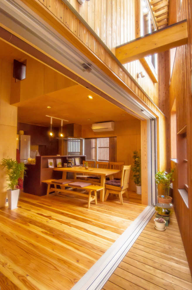 Ispirazione per una sala da pranzo aperta verso la cucina moderna di medie dimensioni con pareti beige, parquet chiaro, pavimento beige, soffitto in legno e pareti in legno