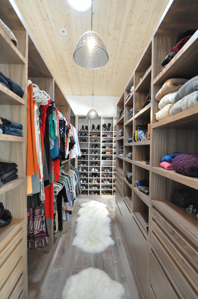 Inspiration for an expansive contemporary gender-neutral walk-in wardrobe in Chicago with medium hardwood floors, flat-panel cabinets, medium wood cabinets and brown floor.