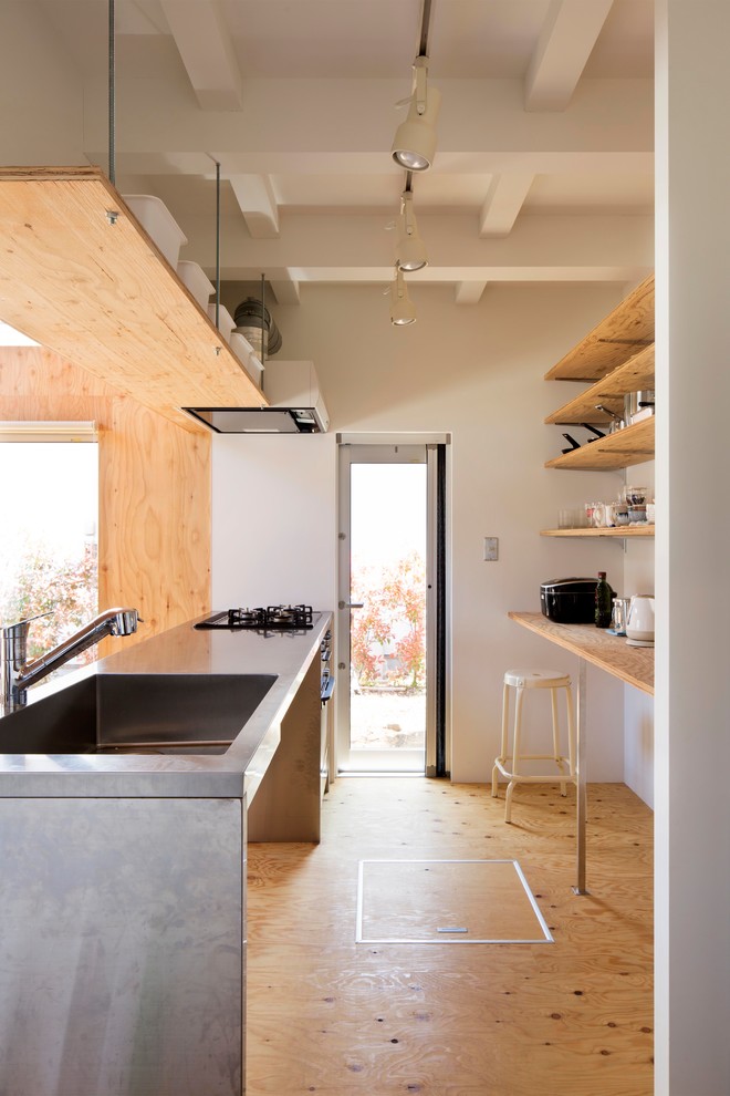 Photo of a contemporary single-wall open plan kitchen in Tokyo Suburbs with an integrated sink, open cabinets, stainless steel benchtops, medium hardwood floors, a peninsula and brown floor.