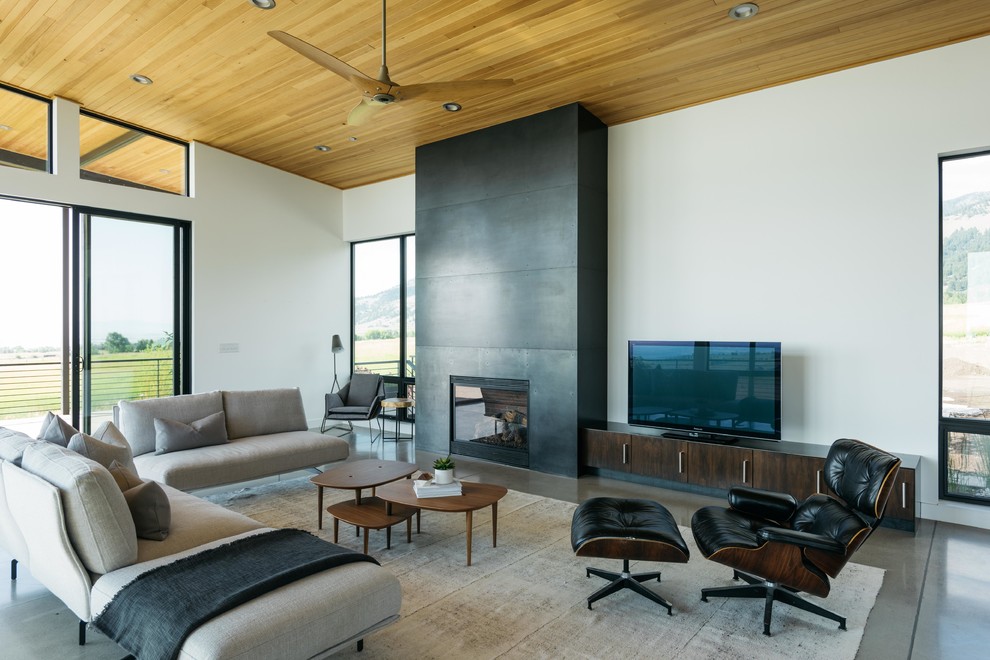 Inspiration for a mid-sized contemporary open concept living room in Other with white walls, concrete floors, a standard fireplace, a metal fireplace surround, a freestanding tv and grey floor.