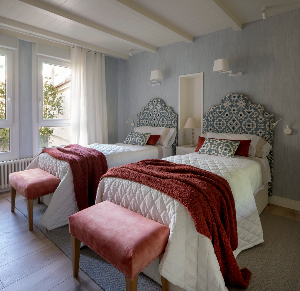 Ejemplo de habitación de invitados clásica renovada grande sin chimenea con paredes azules, suelo laminado y papel pintado