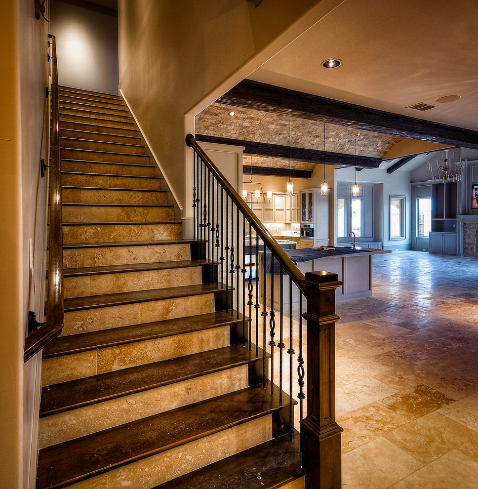 Design ideas for a mid-sized mediterranean wood straight staircase in Austin with travertine risers and metal railing.