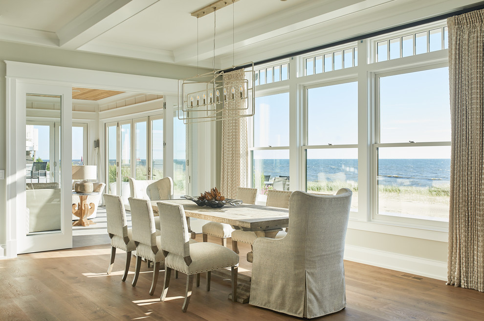 Design ideas for a beach style dining room in Grand Rapids with grey walls, medium hardwood floors and brown floor.