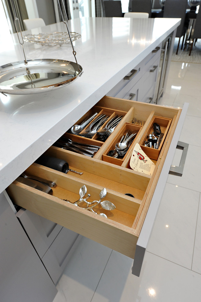 Inspiration for a mid-sized transitional l-shaped porcelain tile kitchen pantry remodel in Toronto with a double-bowl sink, shaker cabinets, gray cabinets, quartz countertops, white backsplash, stone slab backsplash, stainless steel appliances and an island