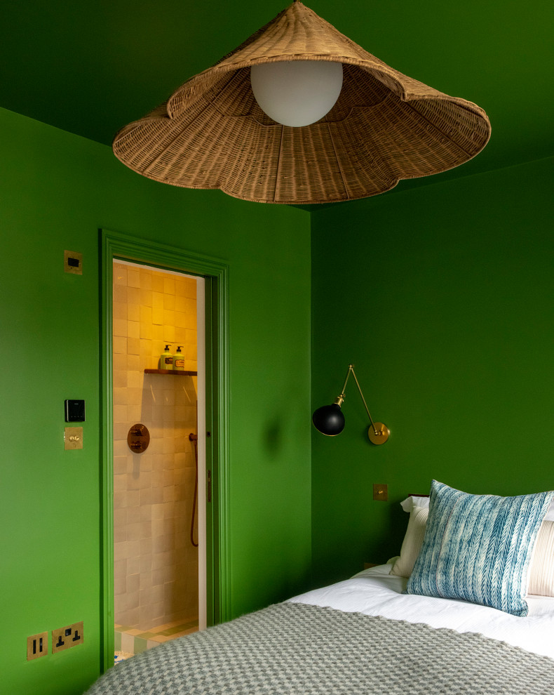 Design ideas for a mid-sized contemporary guest bedroom in London with green walls and medium hardwood floors.