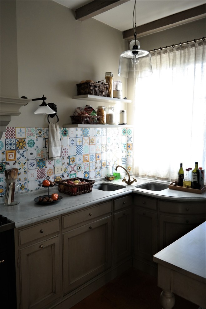 Small country u-shaped separate kitchen in Milan with an undermount sink, beaded inset cabinets, marble benchtops, ceramic splashback and terra-cotta floors.