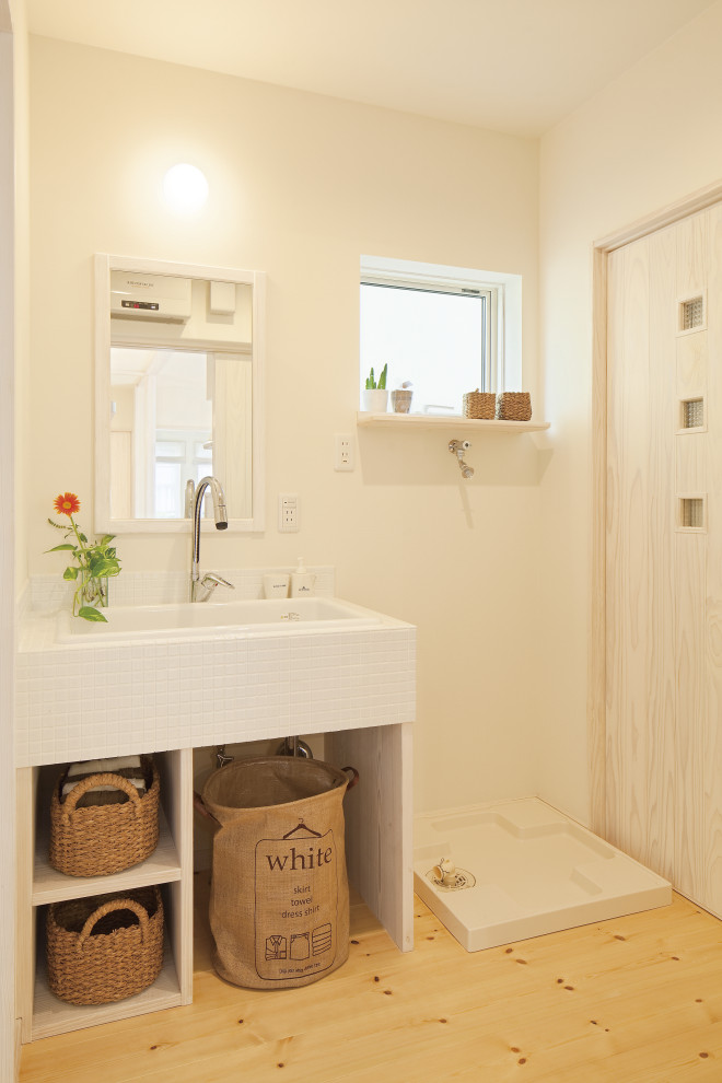 Mid-sized country powder room in Other with open cabinets, white cabinets, a one-piece toilet, white tile, mosaic tile, white walls, light hardwood floors, an undermount sink, tile benchtops, beige floor and white benchtops.
