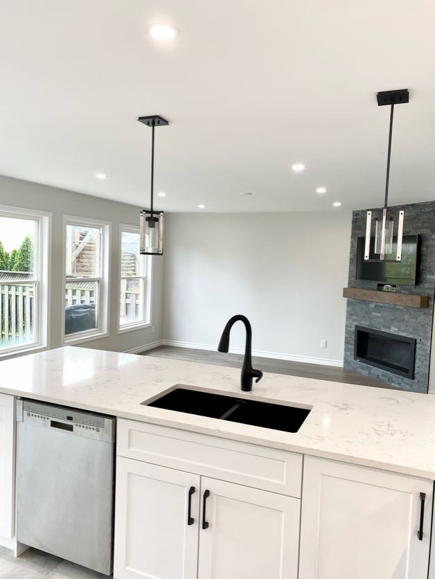 Open concept kitchen - large transitional u-shaped porcelain tile and gray floor open concept kitchen idea with an undermount sink, recessed-panel cabinets, white cabinets, quartzite countertops, gray backsplash, stainless steel appliances, a peninsula and white countertops