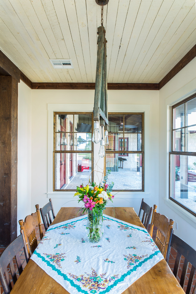 Inspiration for a mid-sized country separate dining room in Austin with white walls, terra-cotta floors and no fireplace.