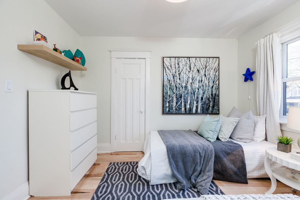 Photo of a small transitional kids' bedroom for kids 4-10 years old and boys in Toronto with white walls and light hardwood floors.