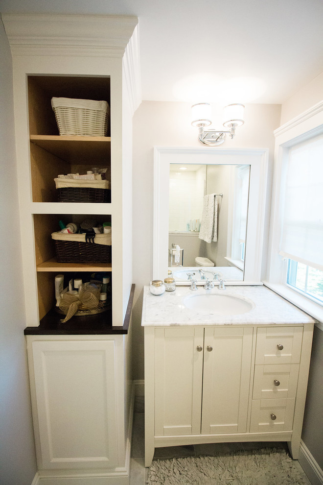 Mid-sized transitional master travertine floor corner shower photo in Boston with shaker cabinets, white cabinets, a two-piece toilet, gray walls, an undermount sink and solid surface countertops