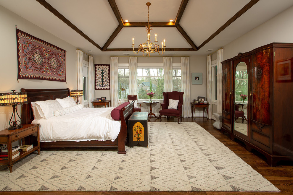 Photo of a large traditional master bedroom in DC Metro with beige walls, dark hardwood floors and brown floor.