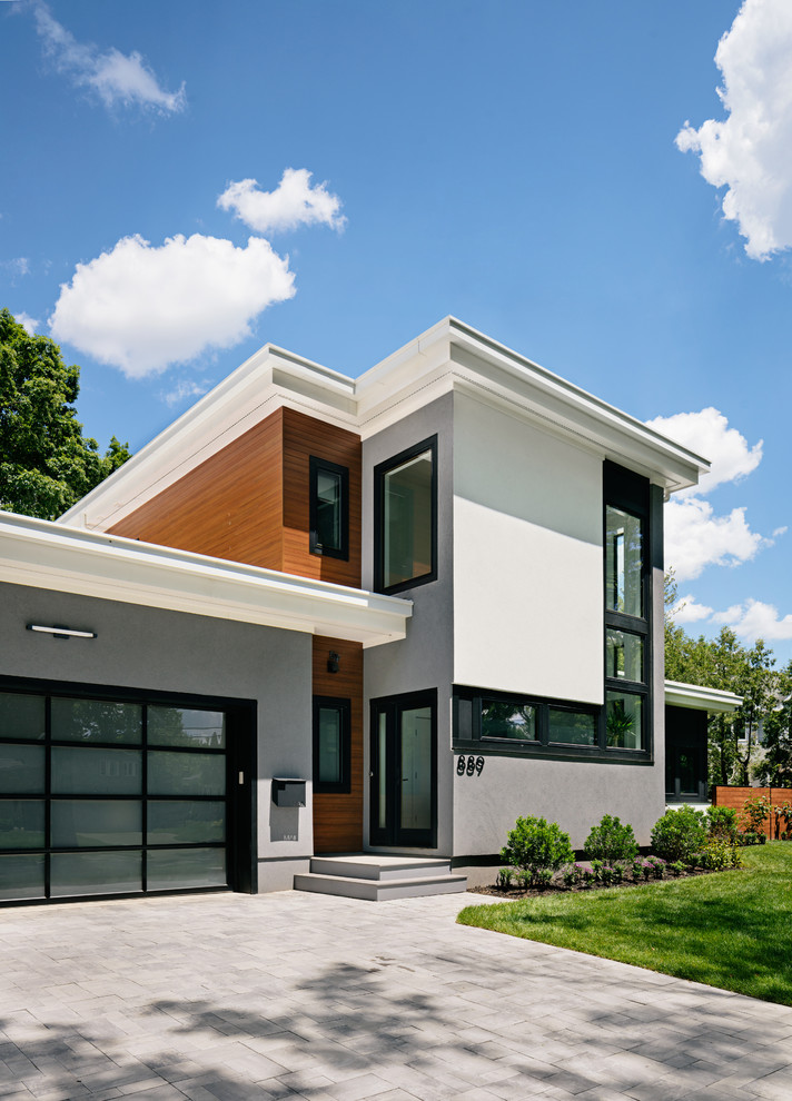 This is an example of a large contemporary two-storey concrete grey house exterior in New York with a flat roof.