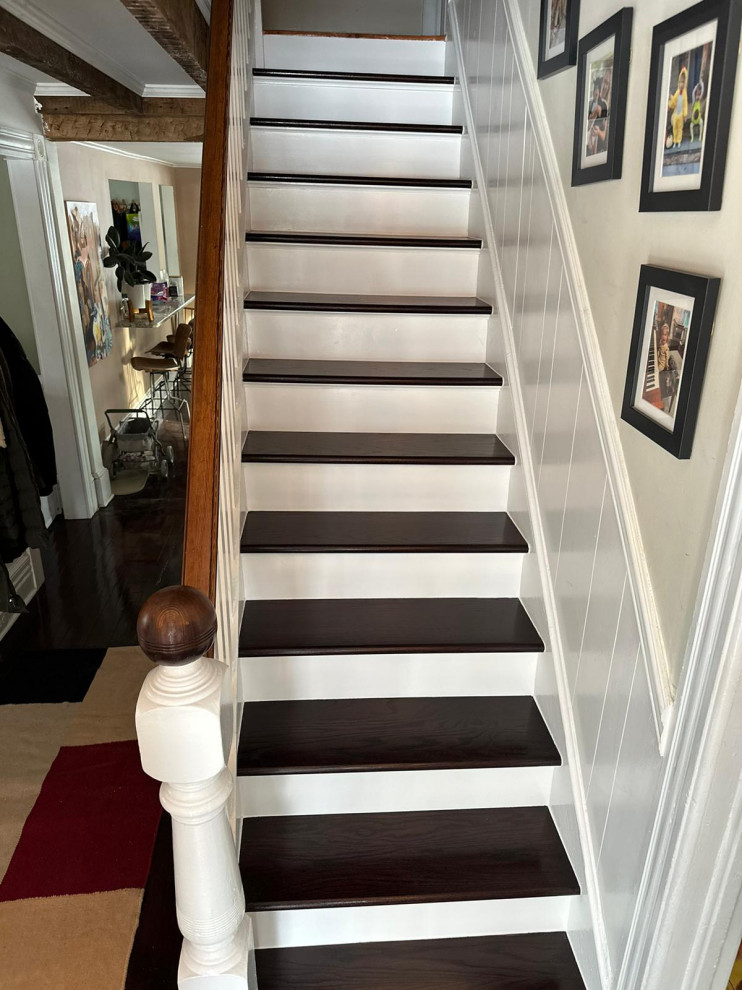 This is an example of a small traditional wood straight staircase in New York with wood risers and wood railing.