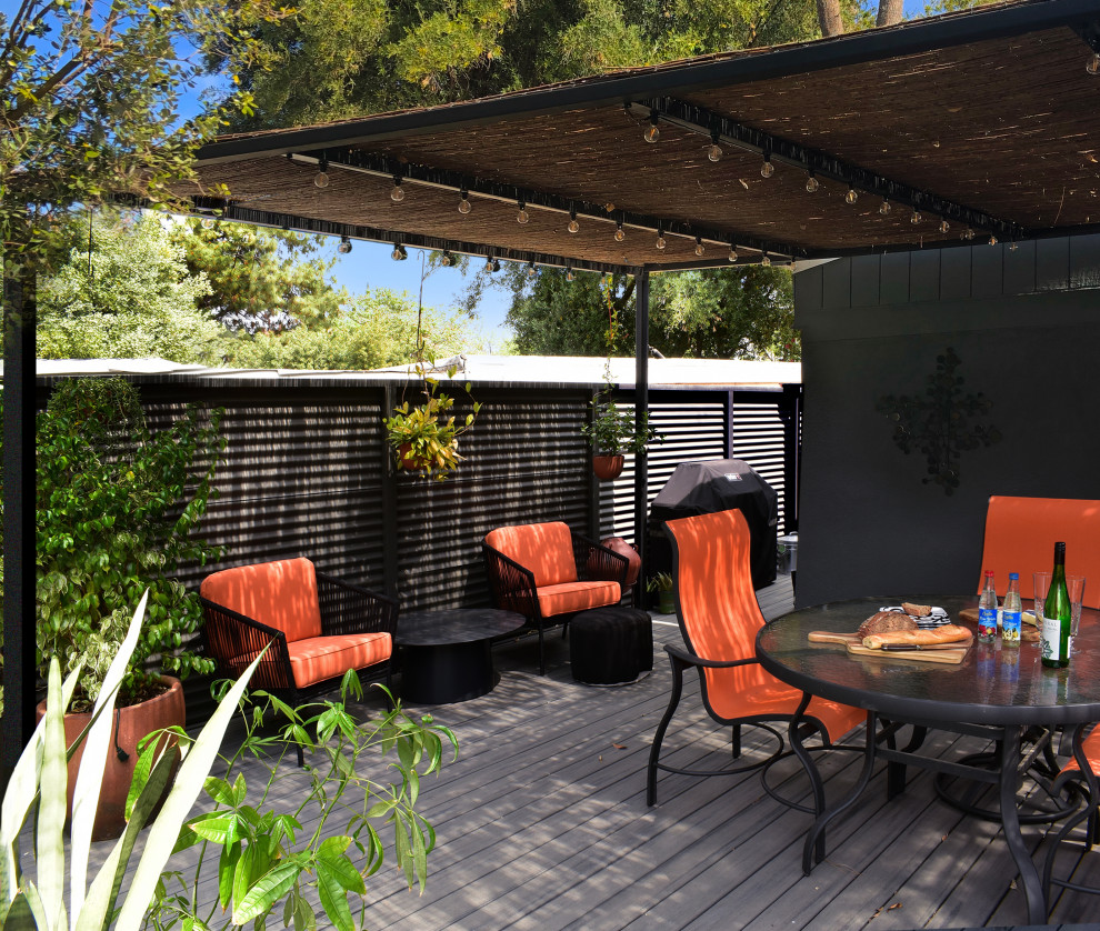 Inspiration for a large midcentury backyard and ground level deck in Los Angeles with a pergola and metal railing.