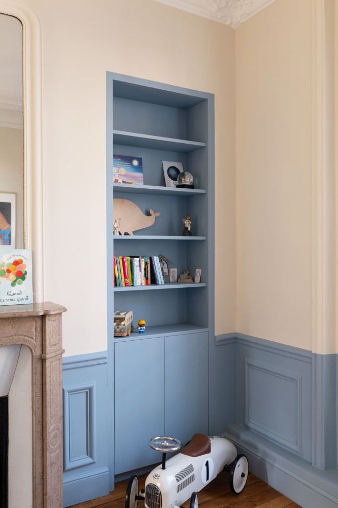 Mittelgroßes Retro Babyzimmer mit blauer Wandfarbe und braunem Holzboden in Paris