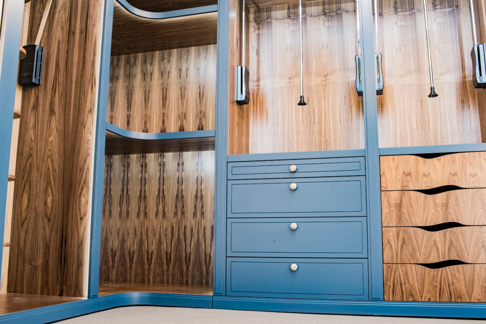 Esempio di una cabina armadio unisex minimal di medie dimensioni con ante in stile shaker e ante in legno bruno