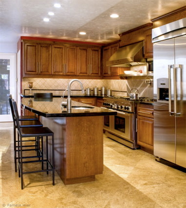 Mid-sized traditional galley eat-in kitchen in Orange County with a single-bowl sink, raised-panel cabinets, brown cabinets, granite benchtops, beige splashback, limestone splashback, stainless steel appliances, porcelain floors, with island, beige floor and black benchtop.