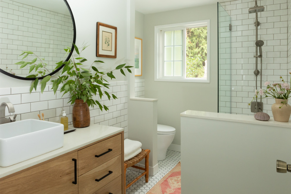 Idée de décoration pour une petite salle de bain vintage en bois clair avec un placard à porte plane, une baignoire en alcôve, un combiné douche/baignoire, WC à poser, un carrelage blanc, des carreaux de céramique, un mur gris, un sol en carrelage de porcelaine, une vasque, un plan de toilette en quartz modifié, un sol blanc, une cabine de douche à porte battante, un plan de toilette blanc, meuble simple vasque et meuble-lavabo sur pied.