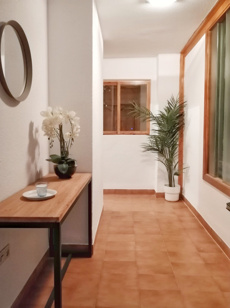 На фото: коридор среднего размера в стиле фьюжн с белыми стенами, полом из керамической плитки и коричневым полом с