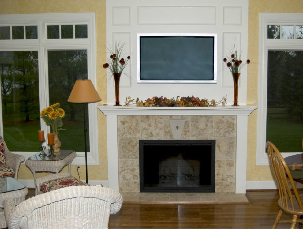 Mid-sized transitional dark wood floor open concept kitchen photo in Cincinnati with white walls, a standard fireplace, a tile fireplace, a wall-mounted tv, raised-panel cabinets, white cabinets and two islands