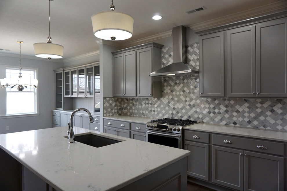 Kitchen - large contemporary medium tone wood floor and brown floor kitchen idea with an undermount sink, recessed-panel cabinets, gray cabinets, quartzite countertops, gray backsplash, mosaic tile backsplash, stainless steel appliances and an island