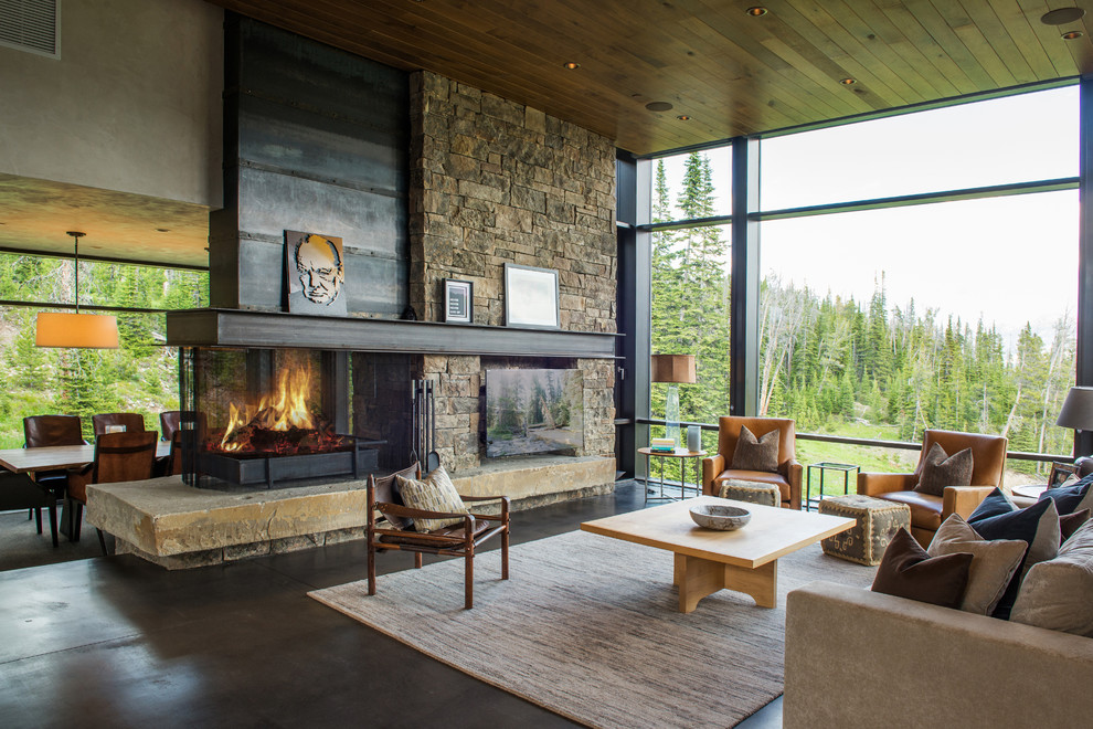 Inspiration for a large country open concept living room in Other with a two-sided fireplace, a metal fireplace surround, a wall-mounted tv, concrete floors, grey floor and beige walls.