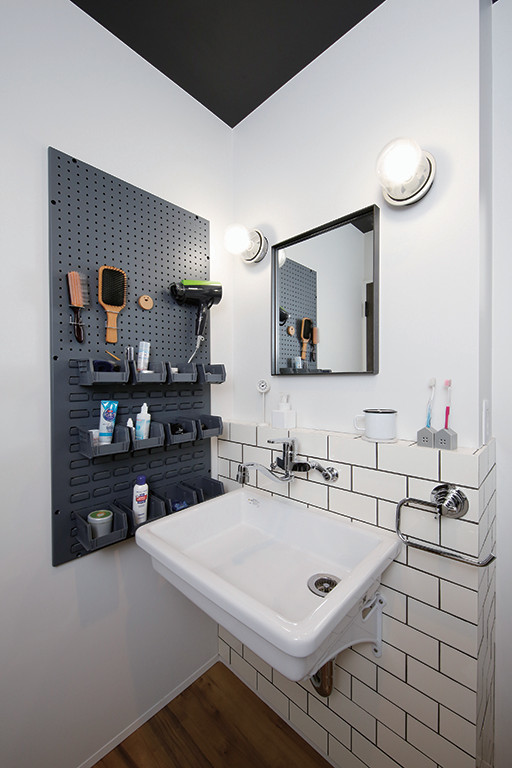 Photo of a mid-sized industrial powder room in Tokyo Suburbs with open cabinets, white cabinets, white tile, subway tile, white walls, dark hardwood floors, a wall-mount sink, solid surface benchtops, brown floor, white benchtops, a floating vanity, wallpaper and wallpaper.