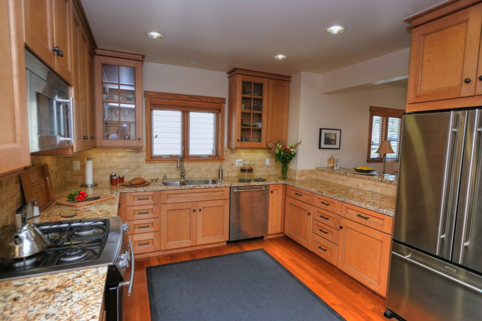 Design ideas for a small traditional u-shaped separate kitchen in Santa Barbara with an undermount sink, shaker cabinets, light wood cabinets, laminate benchtops, beige splashback, ceramic splashback, stainless steel appliances and medium hardwood floors.