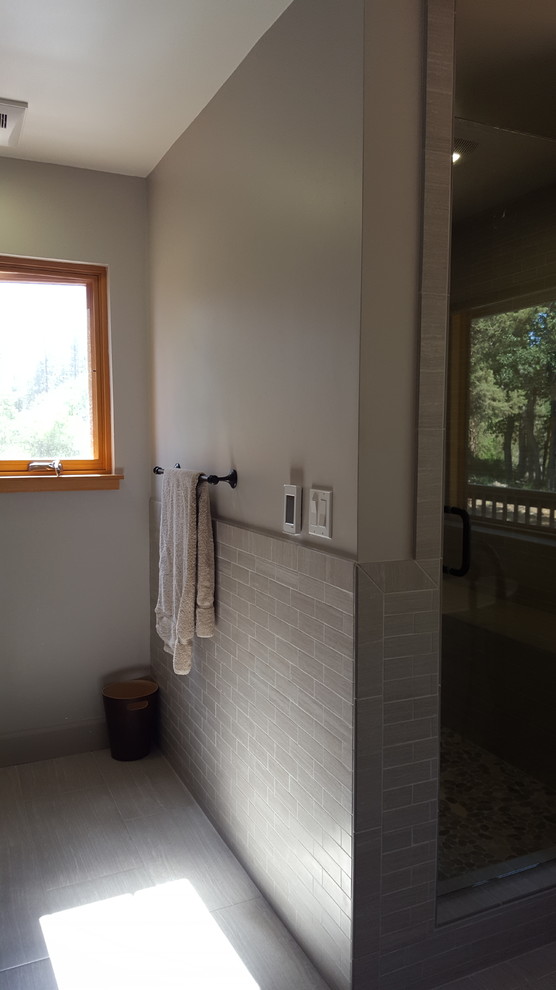 Example of a large mountain style master gray tile and ceramic tile ceramic tile home design design with shaker cabinets, medium tone wood cabinets, a one-piece toilet, gray walls, a drop-in sink and granite countertops