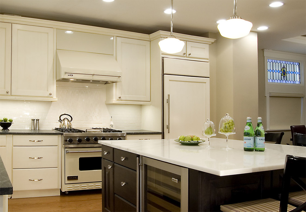 This is an example of a traditional l-shaped kitchen in Chicago with recessed-panel cabinets, white cabinets, marble benchtops, white splashback and white appliances.