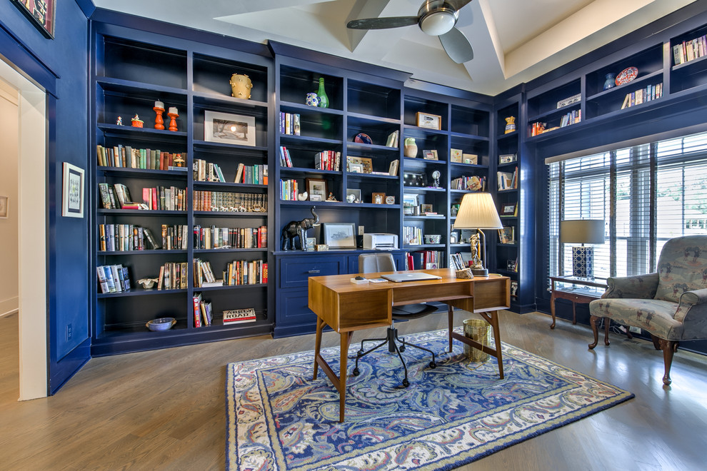 This is an example of a transitional home office in Kansas City with blue walls, dark hardwood floors, a freestanding desk and brown floor.