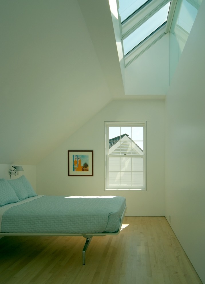 Inspiration for a contemporary bedroom in Portland Maine with white walls and medium hardwood floors.