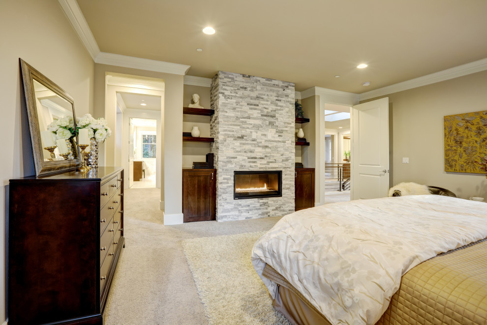 На фото: хозяйская спальня среднего размера в стиле кантри с бежевыми стенами, ковровым покрытием, стандартным камином, фасадом камина из каменной кладки и бежевым полом