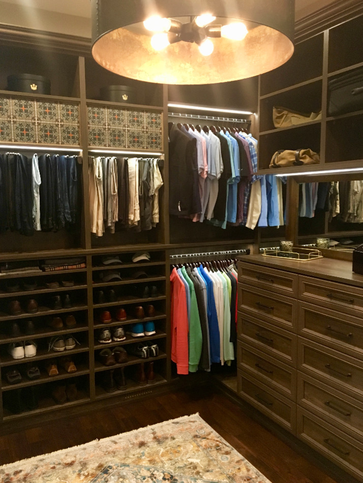 Design ideas for a large traditional men's walk-in wardrobe in Minneapolis with raised-panel cabinets, dark wood cabinets, dark hardwood floors and brown floor.
