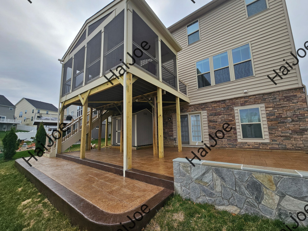 Idee per un ampio portico chic dietro casa con un portico chiuso, cemento stampato, un tetto a sbalzo e parapetto in materiali misti
