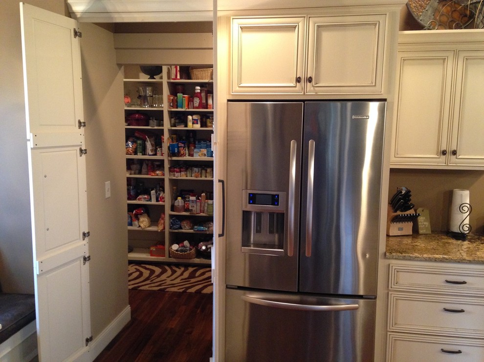 Large transitional l-shaped medium tone wood floor and brown floor kitchen pantry photo with recessed-panel cabinets, white cabinets, laminate countertops, an island, stainless steel appliances and a double-bowl sink