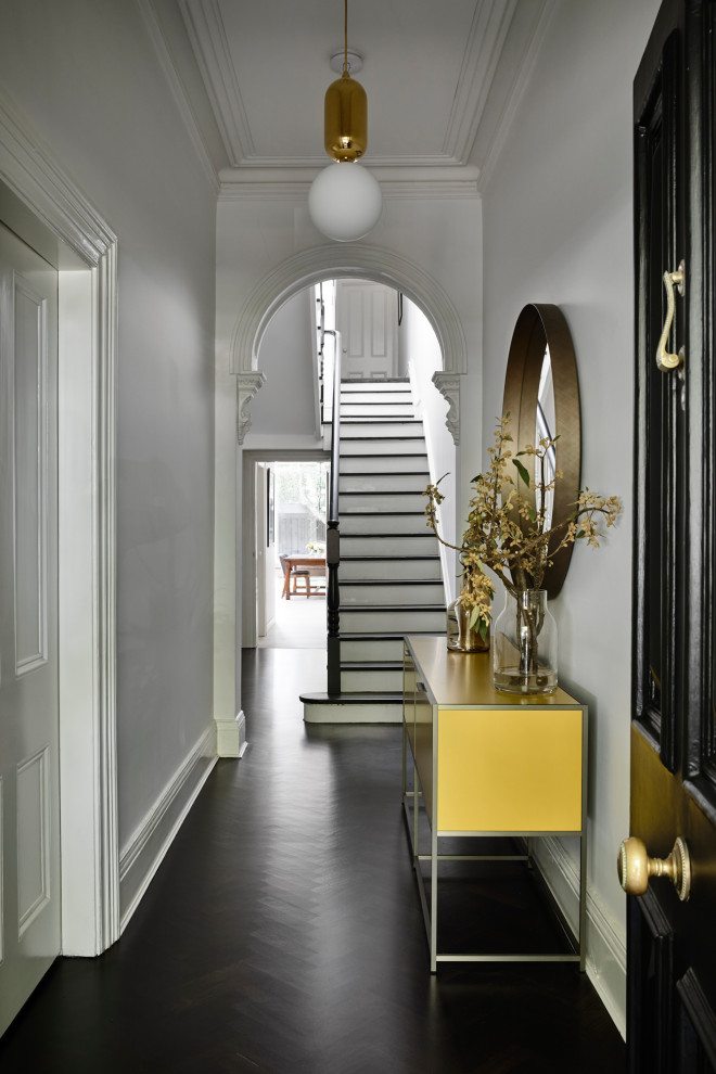Inspiration for a traditional entry hall in Melbourne with white walls, dark hardwood floors and black floor.