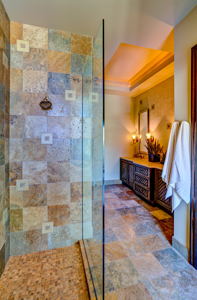 This is an example of a small mediterranean bathroom in Phoenix with an undermount sink, medium wood cabinets, laminate benchtops, an alcove shower, multi-coloured tile and beige walls.