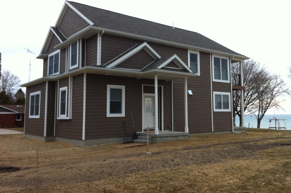 Photo of a large beach style two-storey brown exterior in Detroit with vinyl siding.
