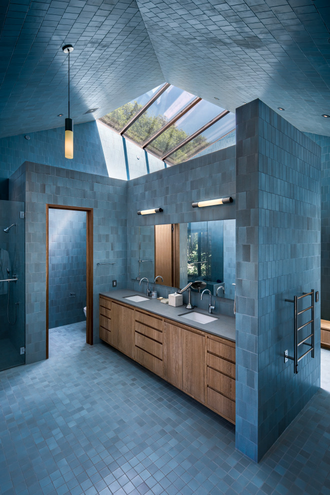 Large contemporary ensuite wet room bathroom in Los Angeles with flat-panel cabinets, light wood cabinets, a freestanding bath, a one-piece toilet, blue tiles, ceramic tiles, blue walls, ceramic flooring, a submerged sink, blue floors, a hinged door, grey worktops, double sinks and a built in vanity unit.