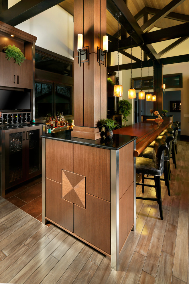 Photo of a large contemporary galley seated home bar in Cincinnati with flat-panel cabinets, medium wood cabinets, copper benchtops, medium hardwood floors and brown floor.