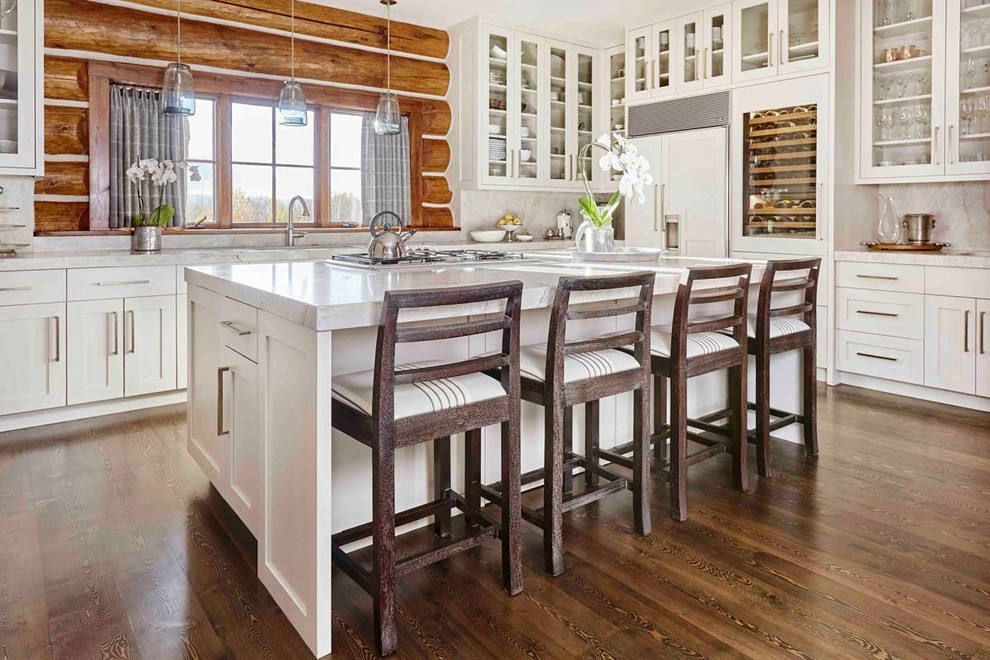 Mid-sized transitional l-shaped open plan kitchen in Other with an undermount sink, shaker cabinets, white cabinets, stainless steel appliances, dark hardwood floors, with island and brown floor.
