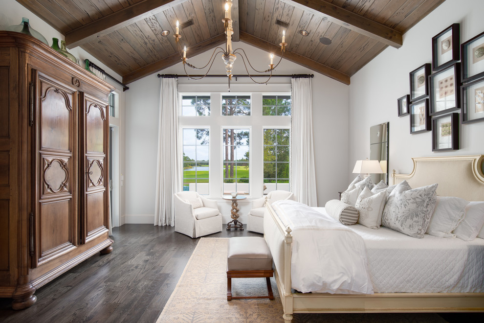 Inspiration for a traditional master bedroom with white walls, dark hardwood floors and no fireplace.