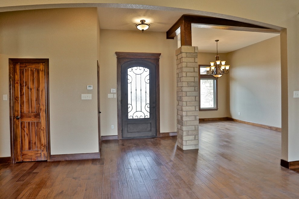 Example of a mid-sized mountain style medium tone wood floor front door design in Dallas with metallic walls and a metal front door