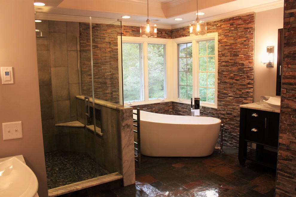 Inspiration for a mid-sized transitional master bathroom in Indianapolis with furniture-like cabinets, dark wood cabinets, a freestanding tub, a double shower, a bidet, multi-coloured tile, stone tile, grey walls, slate floors, a vessel sink and marble benchtops.