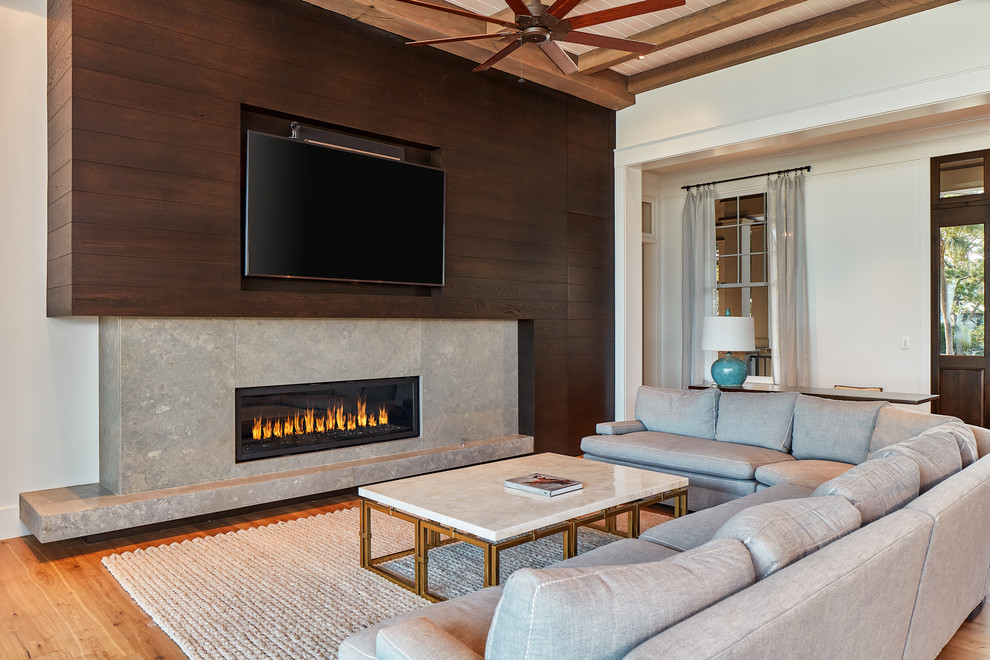 Beach style living room in Atlanta with brown walls, light hardwood floors, a ribbon fireplace and a built-in media wall.